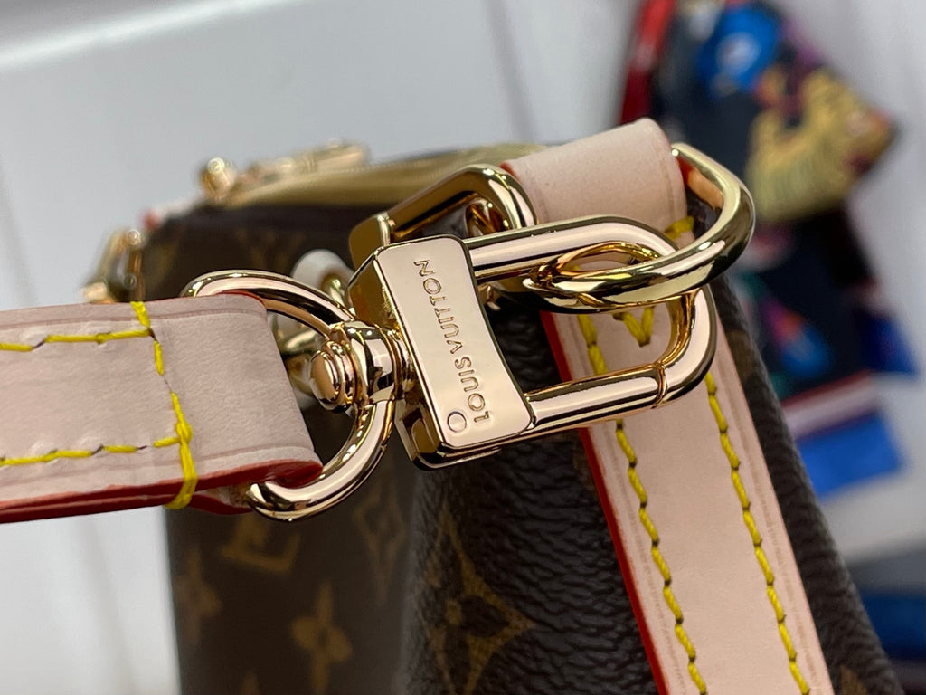 Louis Vuitton monogram bag clasp close-up with gold buckle and linked chain