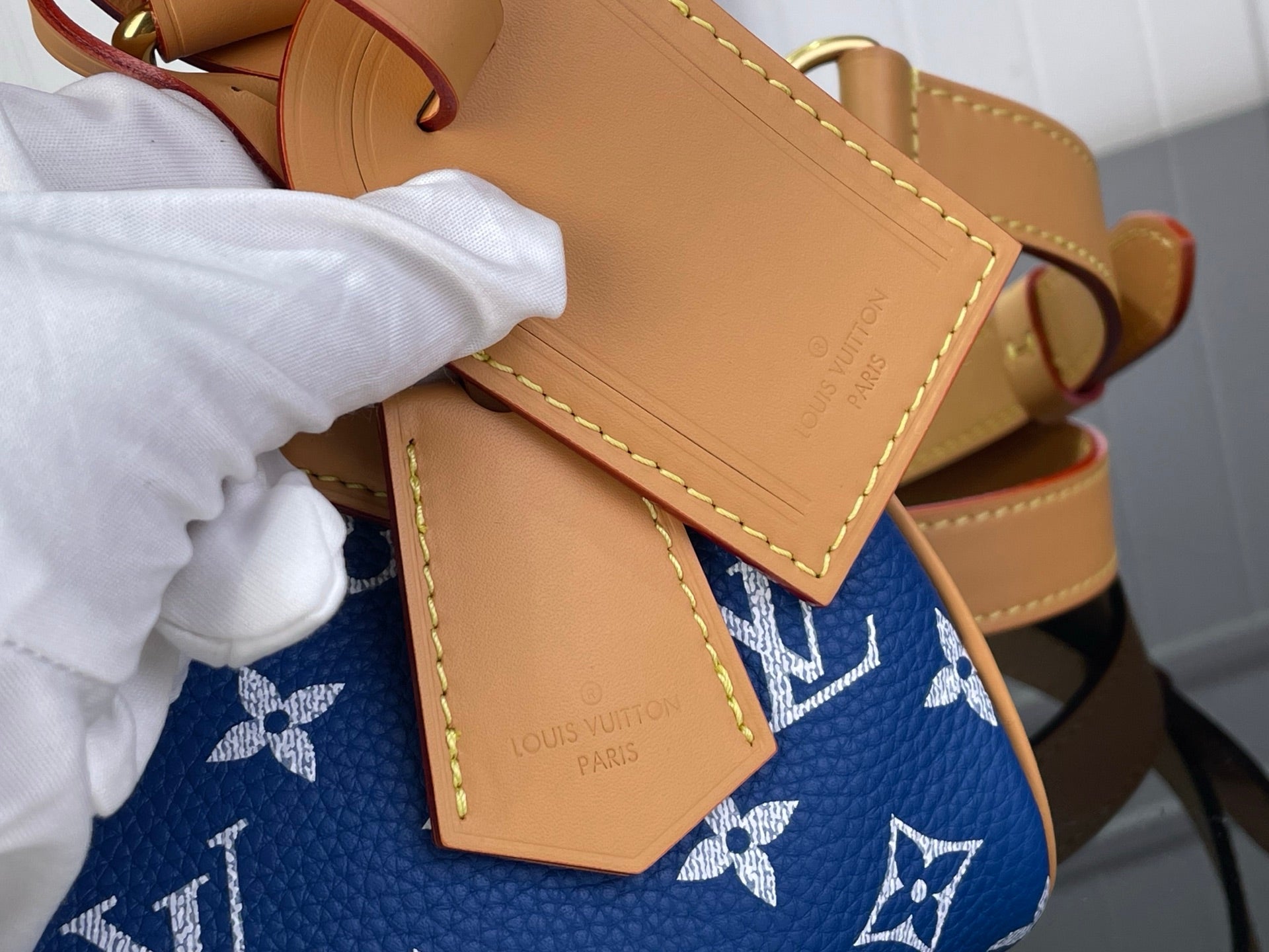 Louis Vuitton blue monogram bag with tan leather pocket flaps and stitching