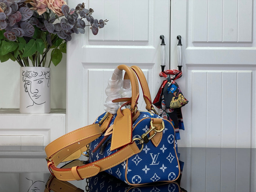 Louis Vuitton blue monogram bag with tan crossbody strap and structured handles