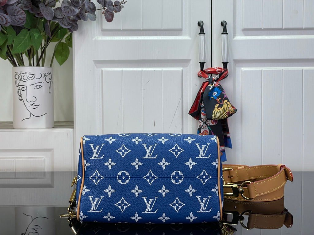 Louis Vuitton blue monogram bag with tan crossbody strap and hanging charm