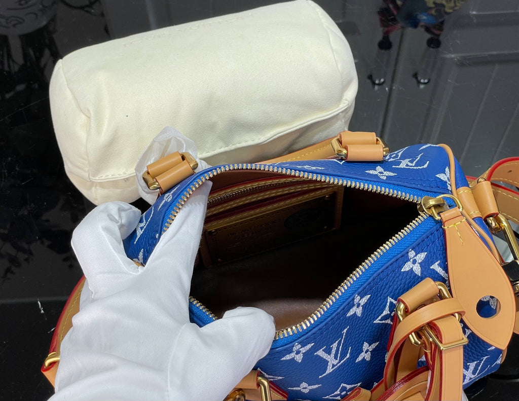 Louis Vuitton bag open top with tan leather lining and blue monogram fabric, interior view