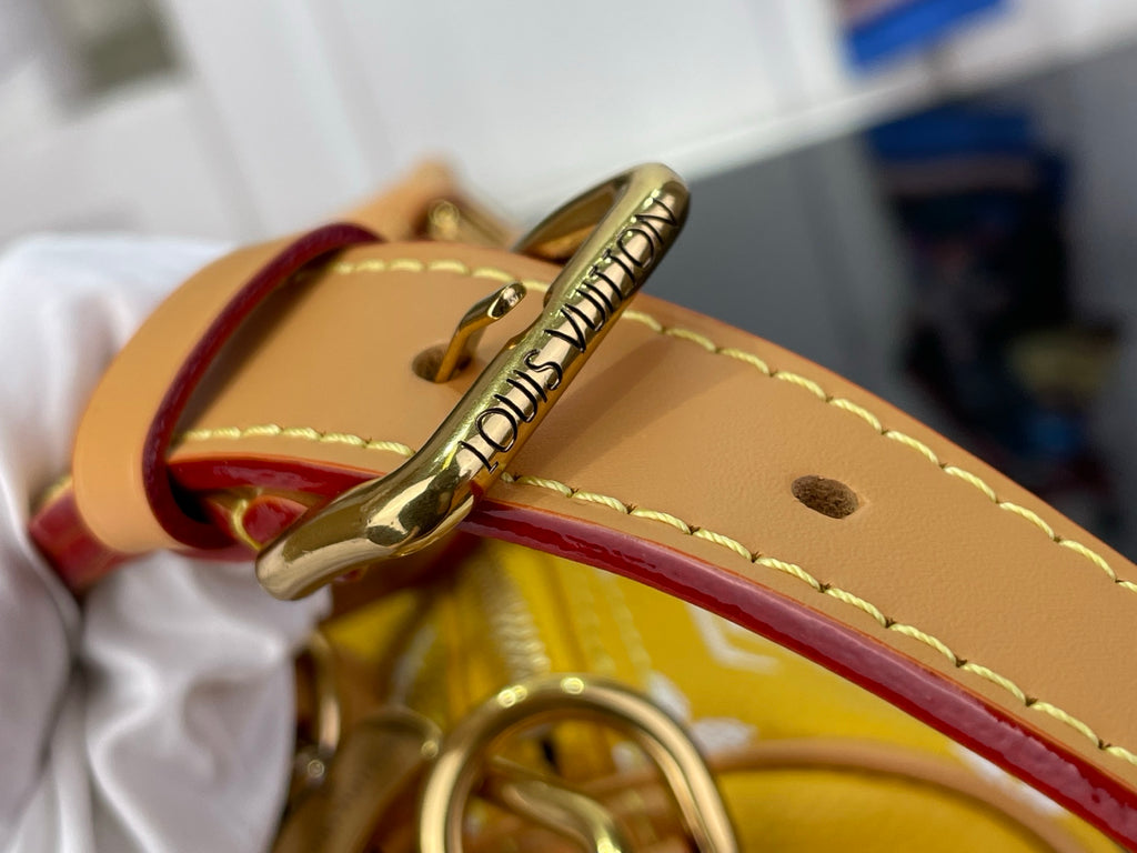 Louis Vuitton bag clasp and tan strap with stitched edge and metal hardware.