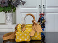 Designer handbag with yellow monogram pattern, tan leather handles, and top flap