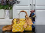 Designer handbag with yellow monogram pattern, tan leather handles, and top flap