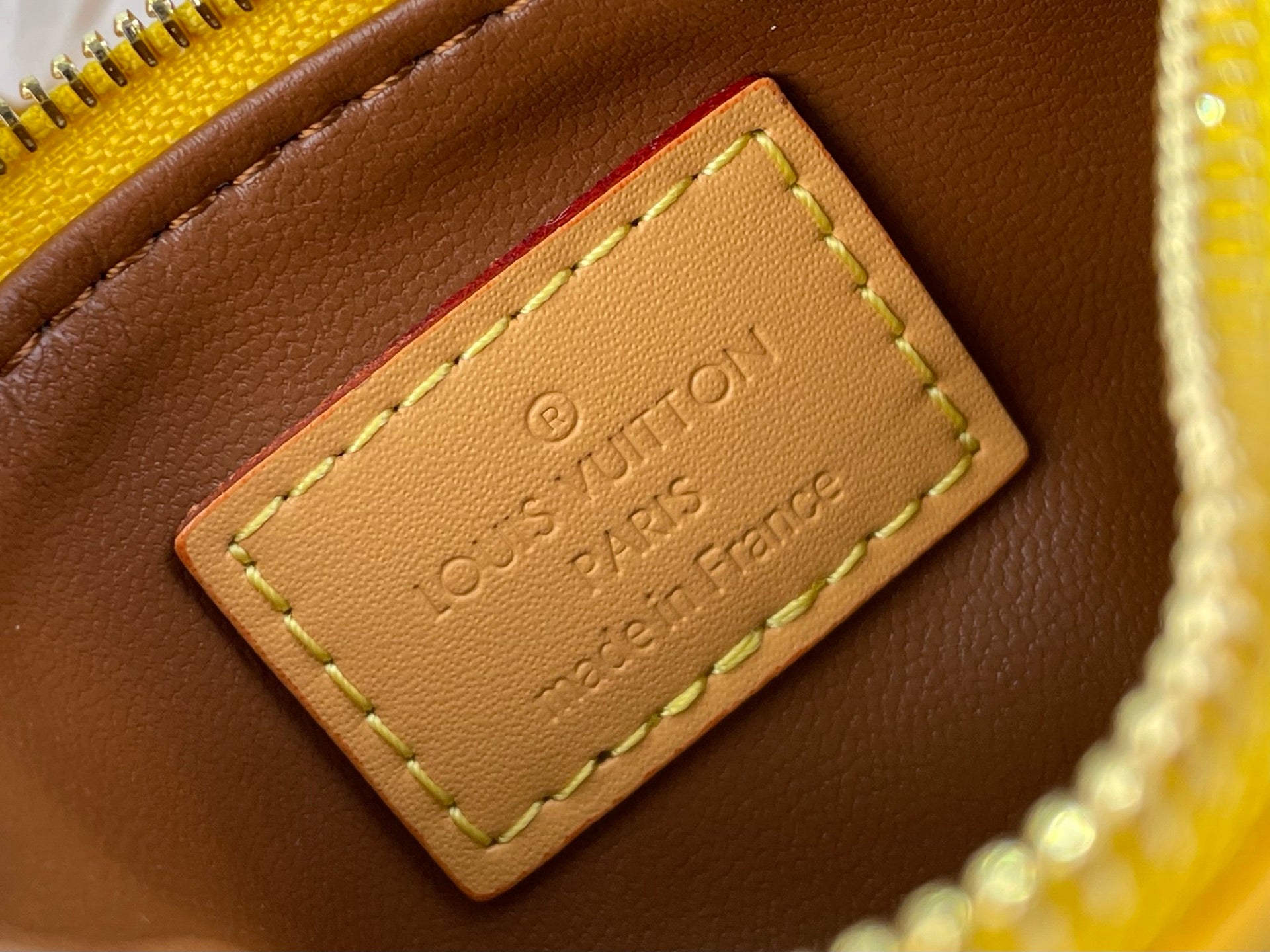 Louis Vuitton bag leather label reading "Louis Vuitton Paris" in embossed text.