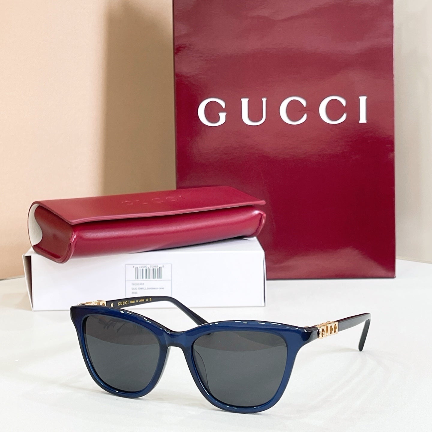 Gucci sunglasses, blue frame with dark gray lenses and gold-tone temple accents