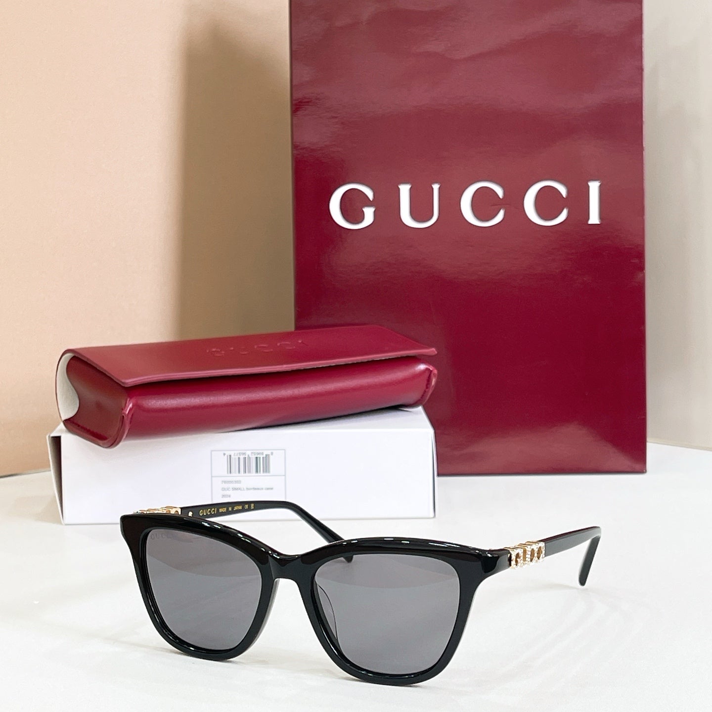 Gucci sunglasses, black frame with gray tinted lenses and gold-tone logo accents
