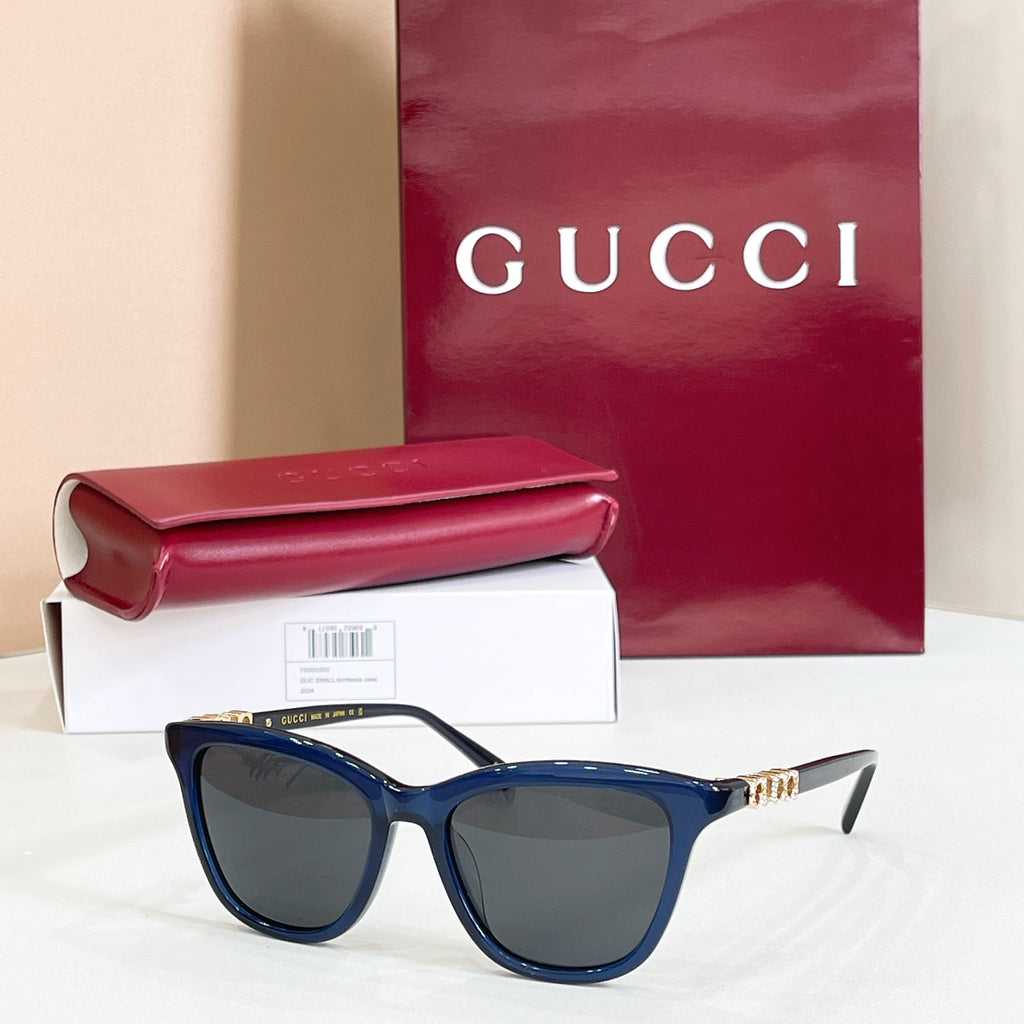 Gucci sunglasses, navy frame with dark gray lenses and gold-tone temple accents