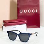 Gucci sunglasses, navy frame with dark gray lenses and gold-tone temple accents
