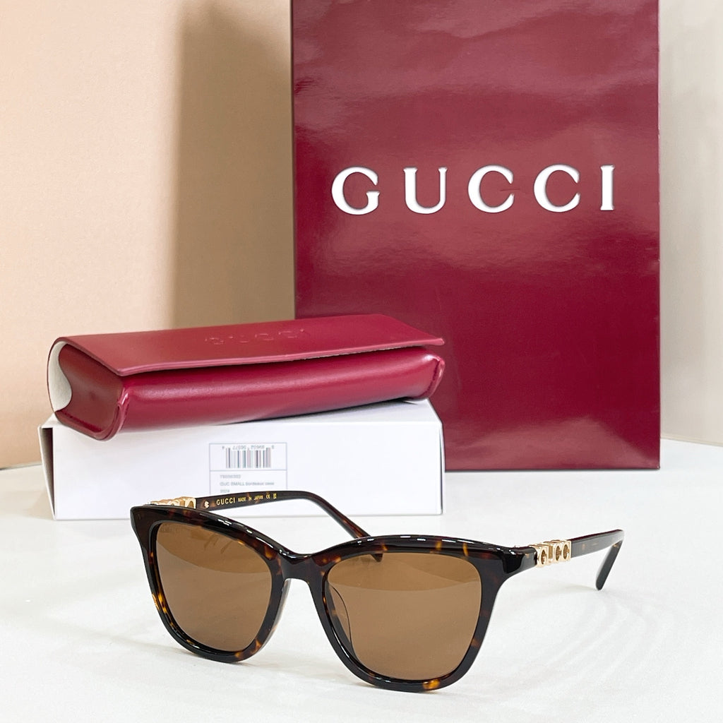 Gucci sunglasses, tortoiseshell frame with brown tinted lenses and gold-tone tips
