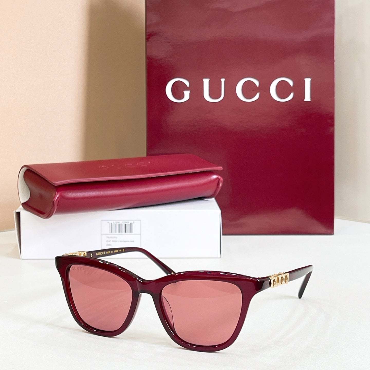 Gucci sunglasses, dark maroon frame with rose tinted lenses and gold-tone accents