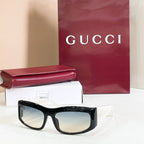 Gucci sunglasses with black oversized frames and light-tinted lenses.