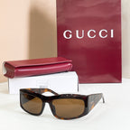 Gucci sunglasses with dark tortoiseshell frames and amber lenses.
