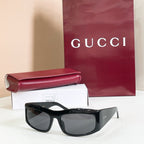 Gucci sunglasses with black oversized frames and dark gray lenses.