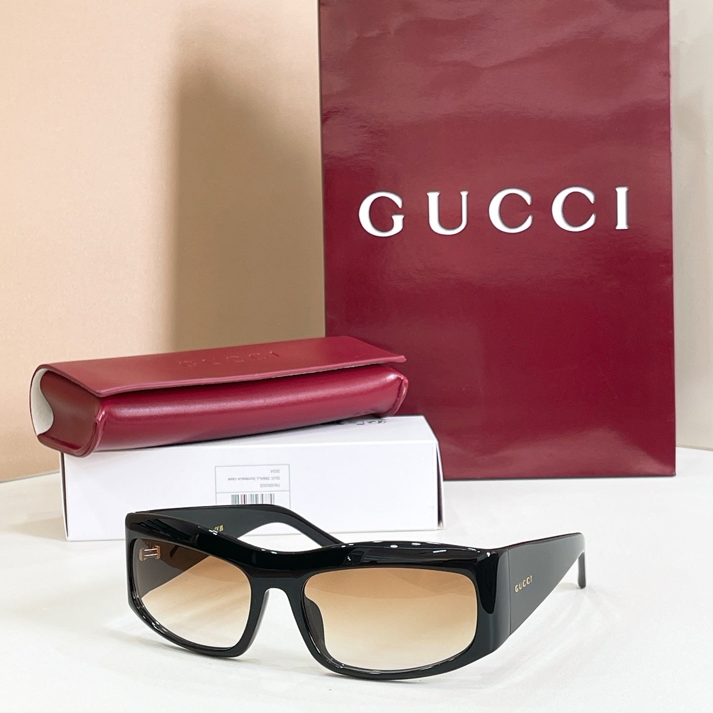 Gucci sunglasses with black oversized frames and beige-tinted lenses.