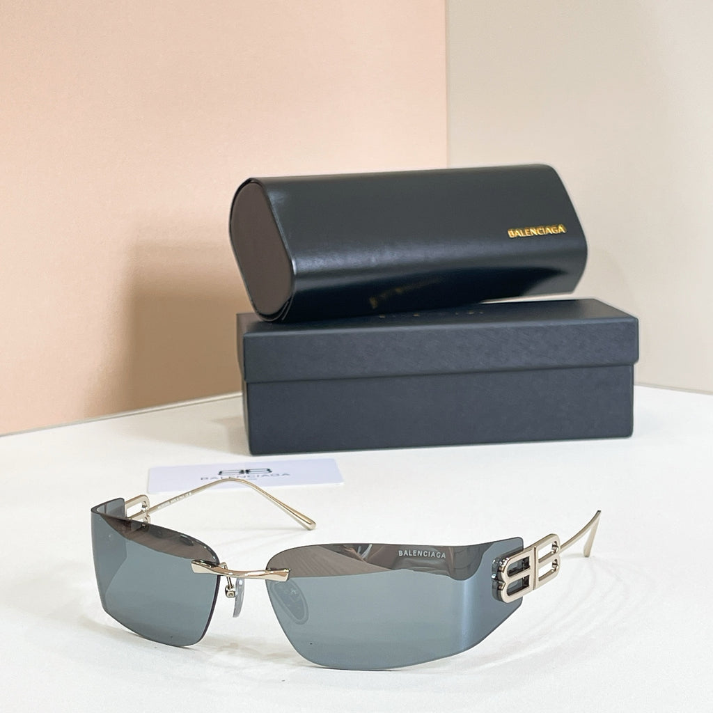 Gold-frame sunglasses with blue-gray gradient lenses and Balenciaga B logo temple detail