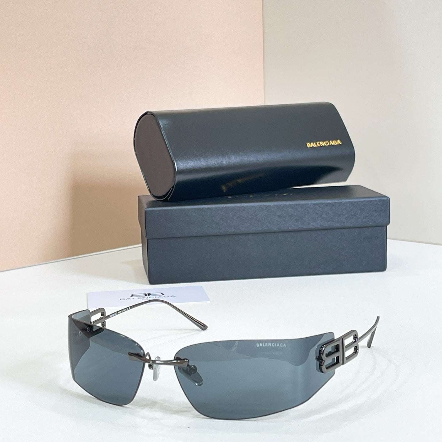 Gold-frame sunglasses with dark blue lenses and Balenciaga B logo temple detail, side view