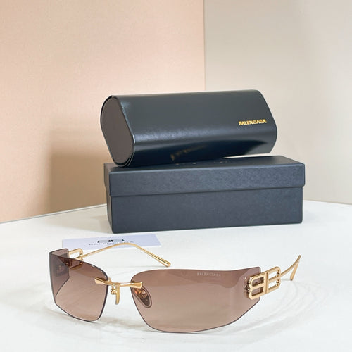 Gold-frame sunglasses with amber gradient lenses and Balenciaga B logo temple detail