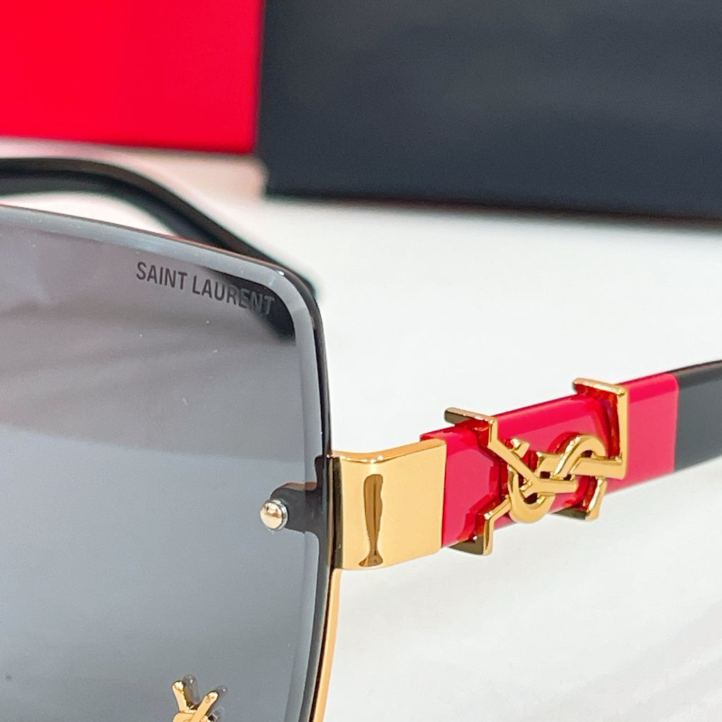 Glasses hinge detail with gold emblem on dark blue frame arm