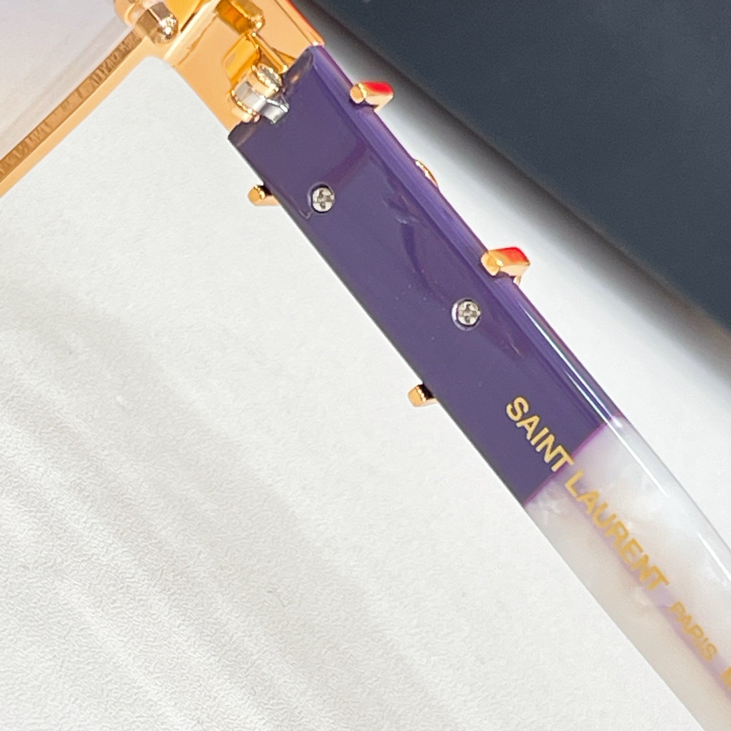 Purple temple arm with SAINT LAURENT text and gold-tone accents