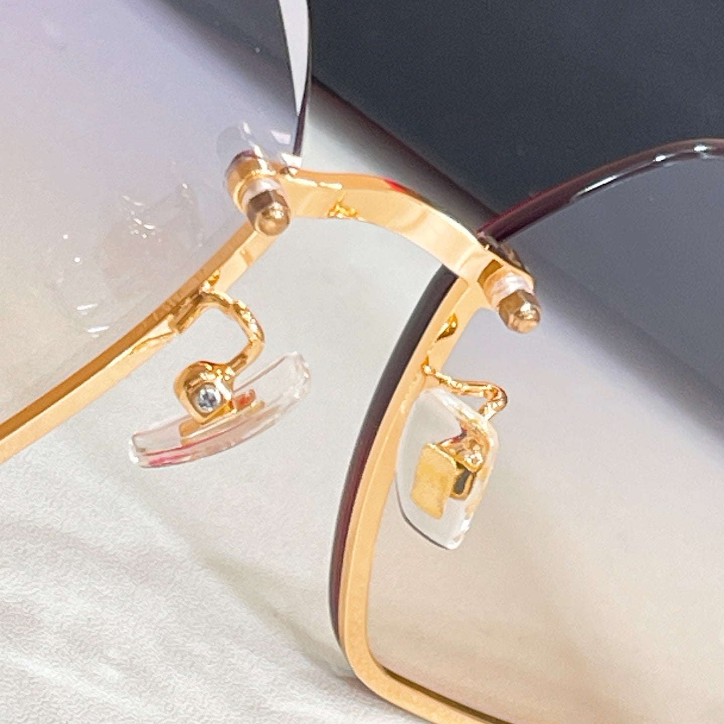 Gold-tone hinge and temple bar on oversized sunglasses with light lens tint