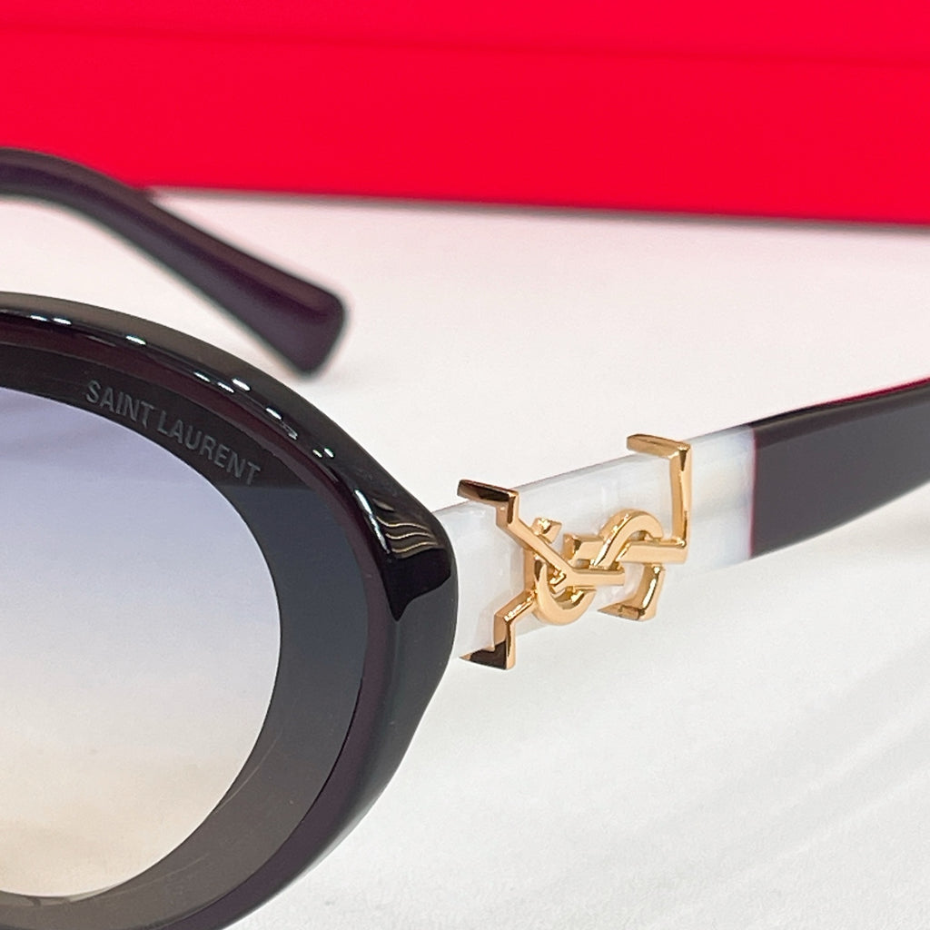 YSL glasses close-up: gold logo detail on black temple