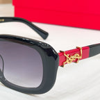 Black eyeglasses close-up with gold emblem and red accent on temple