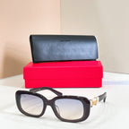 Black rectangular eyeglasses with clear lenses and gold logo detail on temples