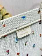 White Dior tote bag label reading Christian Dior and MADE IN ITALY