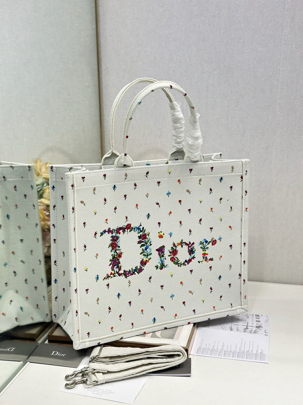 White Dior tote bag with ruched top handles and embroidered multicolor floral letters