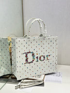 White Dior tote bag with ruched top handles and embroidered multicolor floral letters
