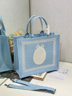 Light blue Dior tote bag with embroidered front logo, top handles, and matching strap