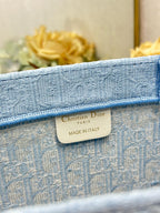 Light blue Dior tote bag fabric tag reading “Christian Dior Paris, Made in Italy”