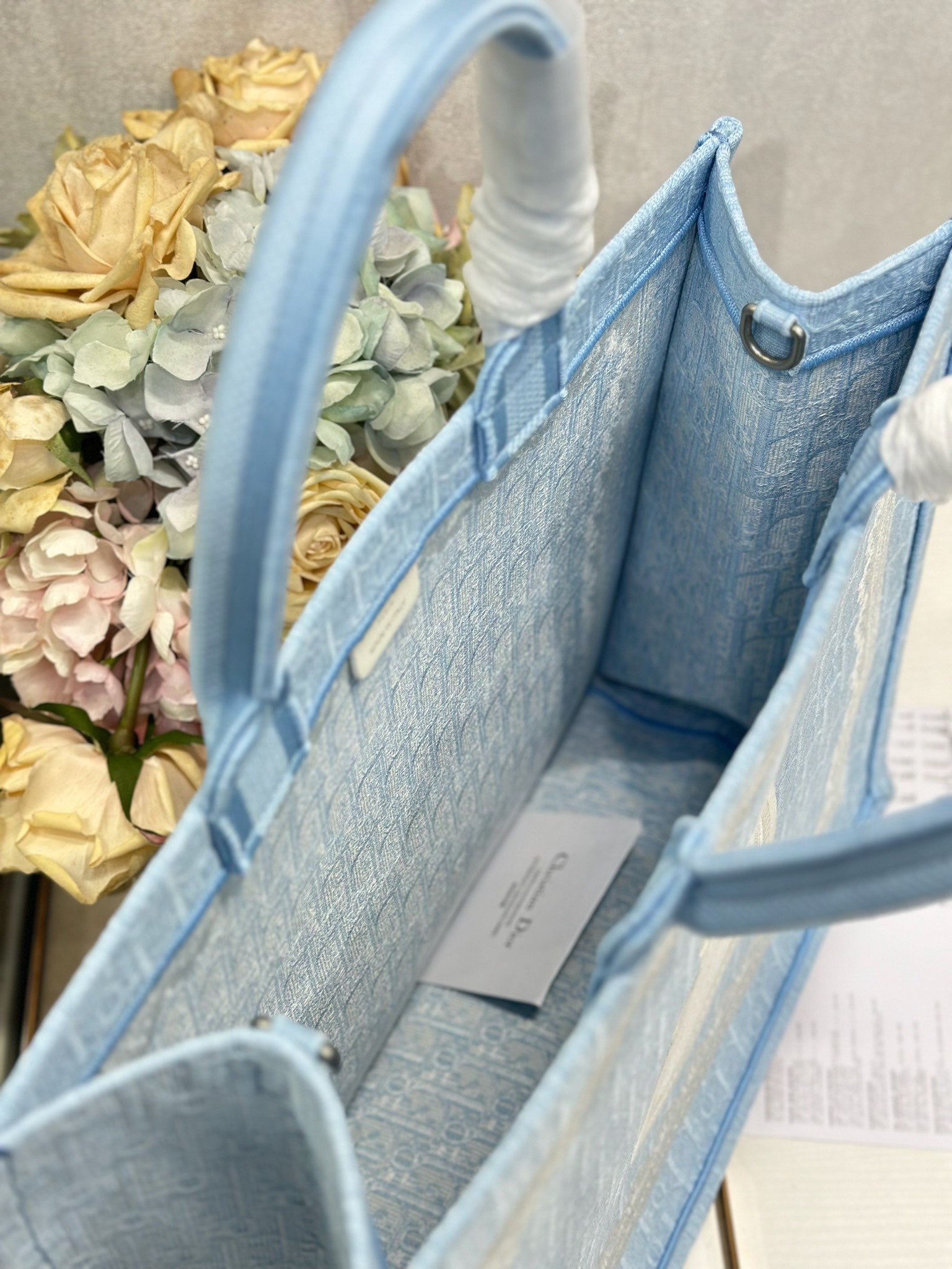Light blue Dior tote bag open view showing interior lining and side panels
