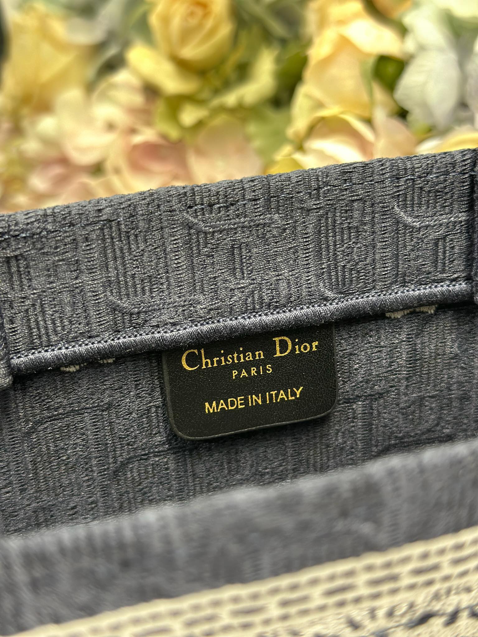 Dior tote bag fabric strap label reading “Christian Dior” and “Made in Italy”
