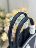 Navy Dior tote bag top handles with gathered white fabric details on the handle grips