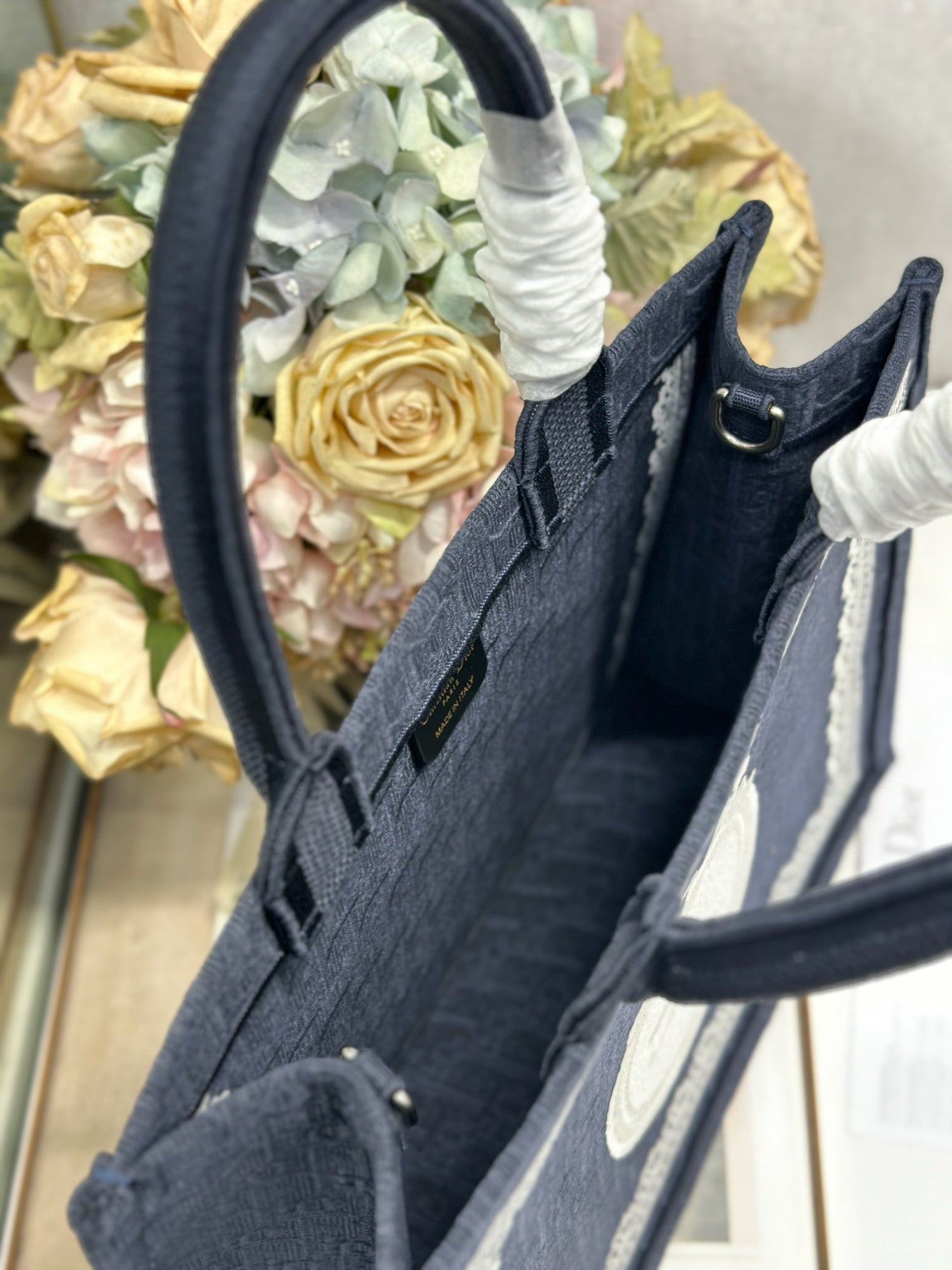 Navy Dior tote bag interior view with side pocket and front logo trim