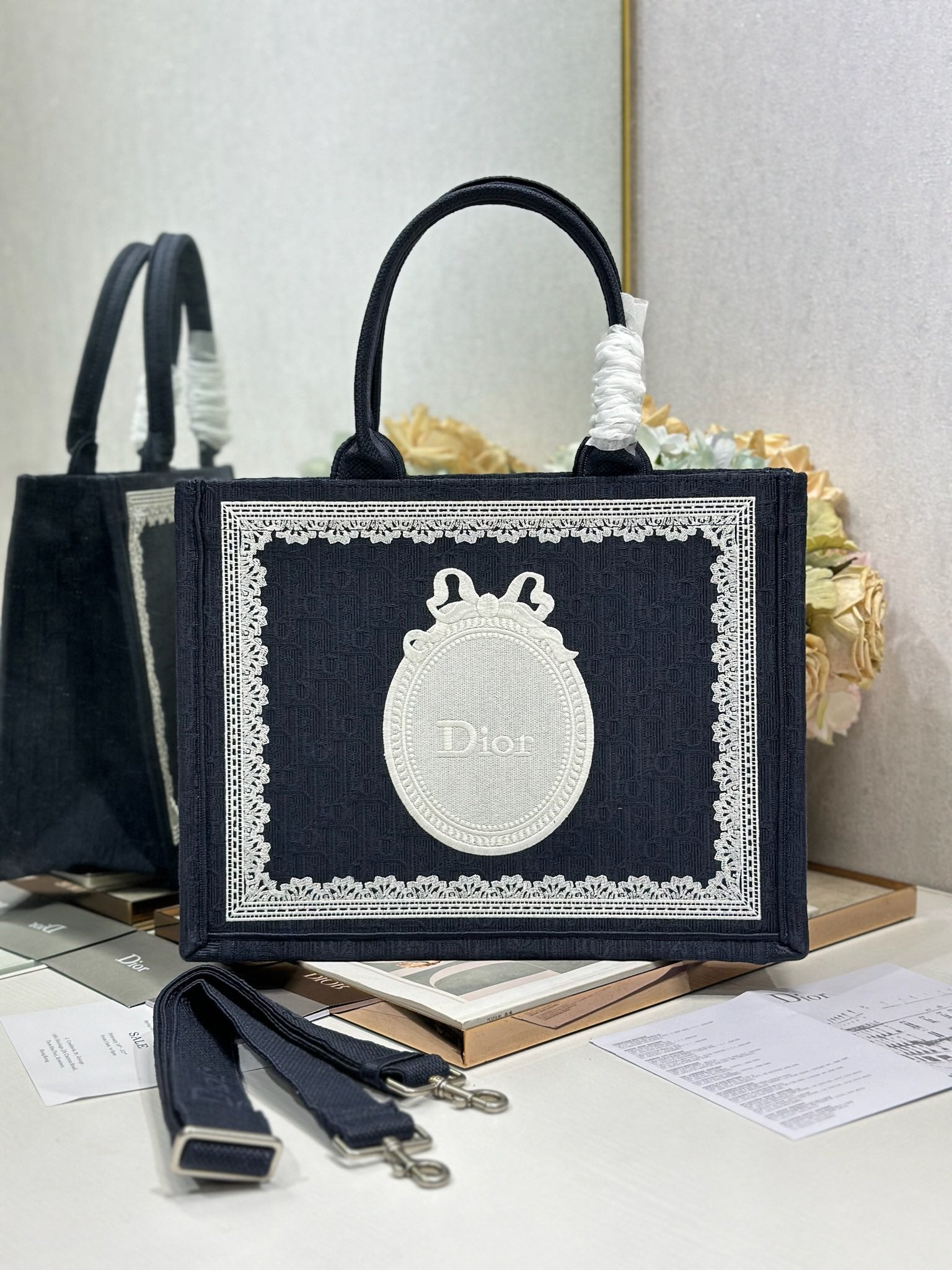 Navy Dior tote bag with top handles and white logo medallion on front panel