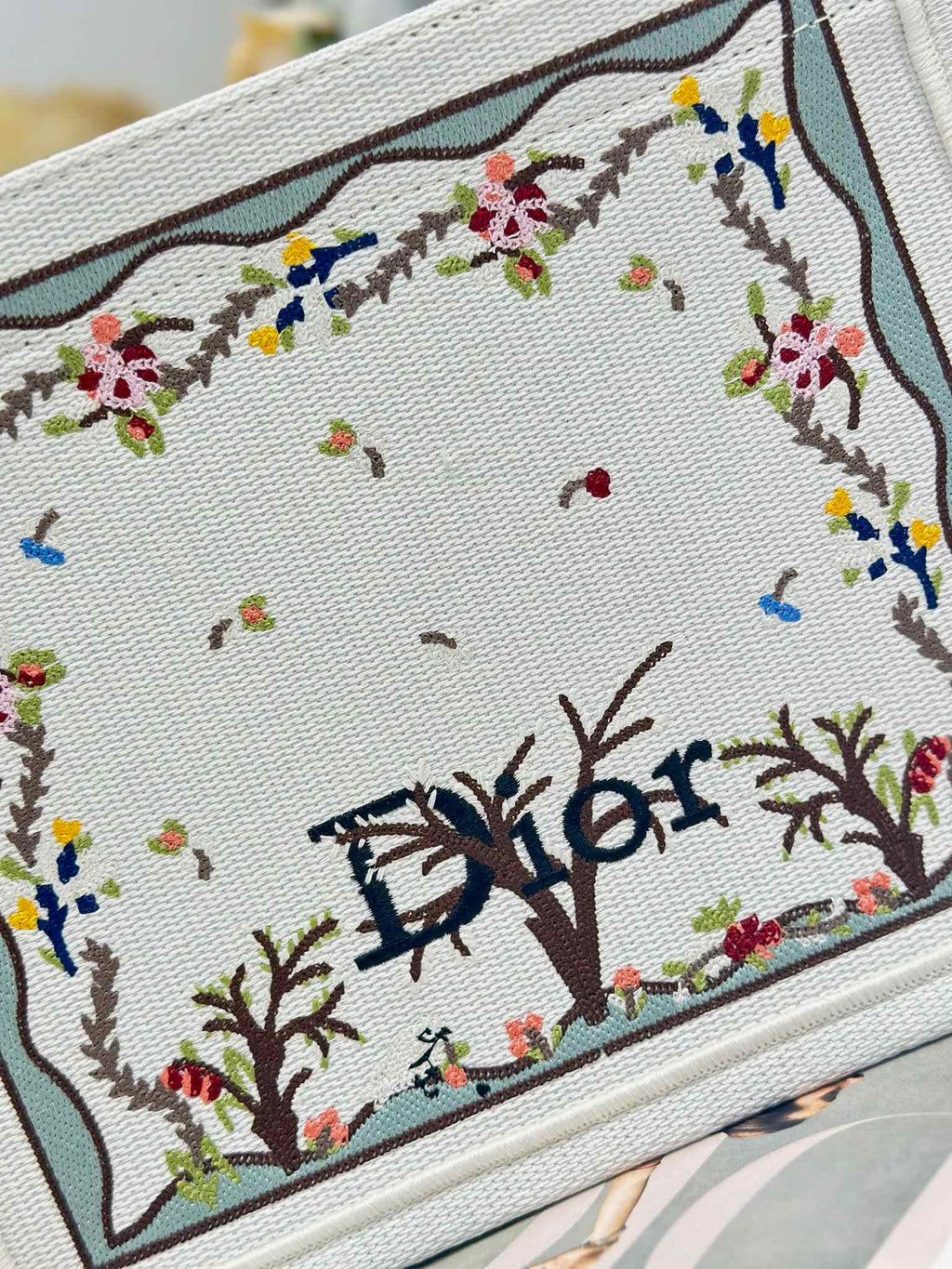 Dior tote bag embroidered panel close-up with colorful floral and tree motifs