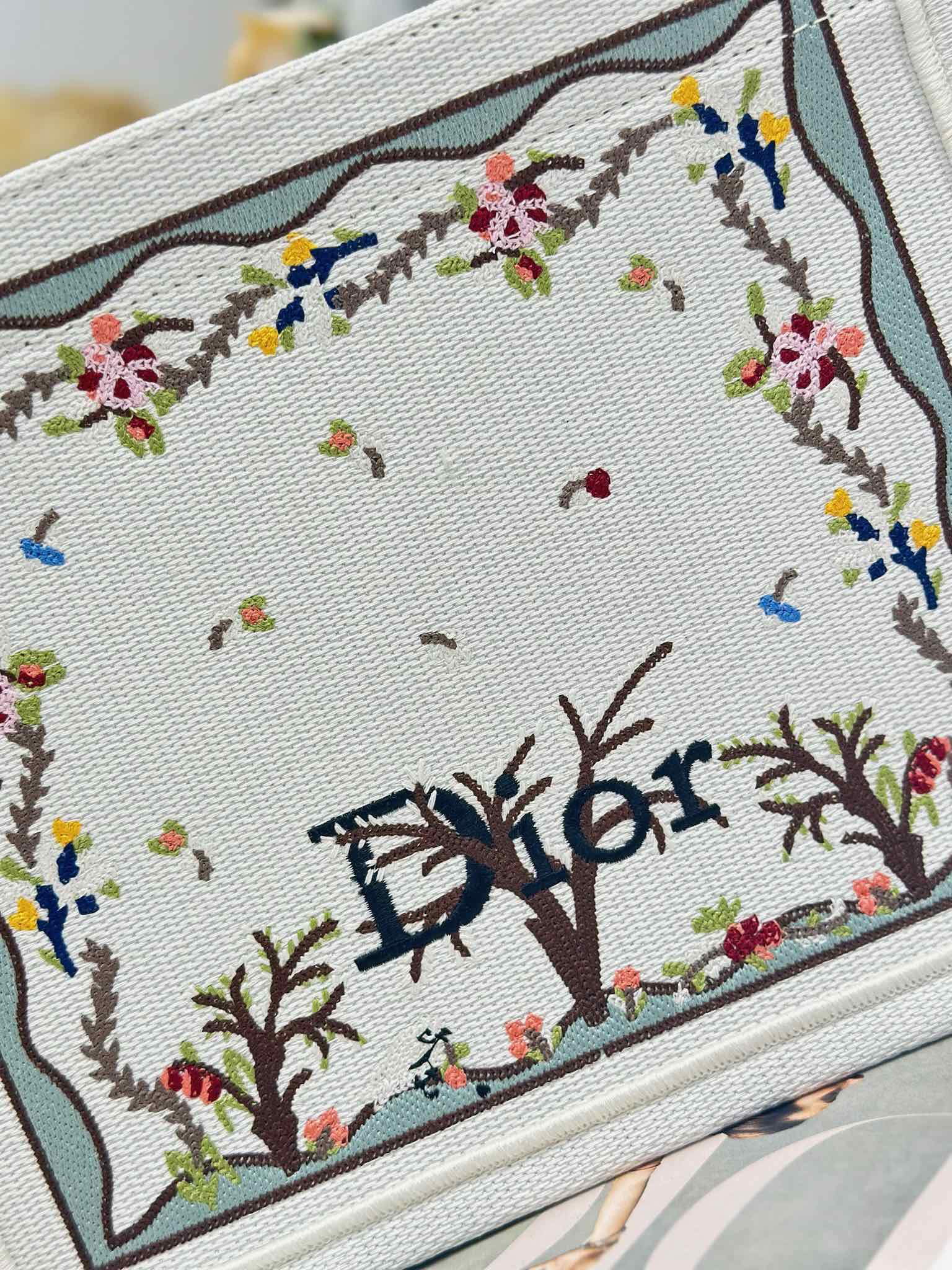 Dior tote bag embroidered panel close-up with colorful floral and tree motifs
