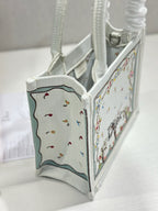 Dior tote bag side view with embroidered panel and light gray interior fabric