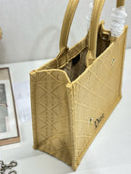Dior gold handbag side view with open top, interior panel, and front Dior logo.