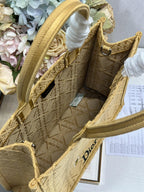 Dior gold handbag detail with top handle, white tassel tie, and textured side panels.