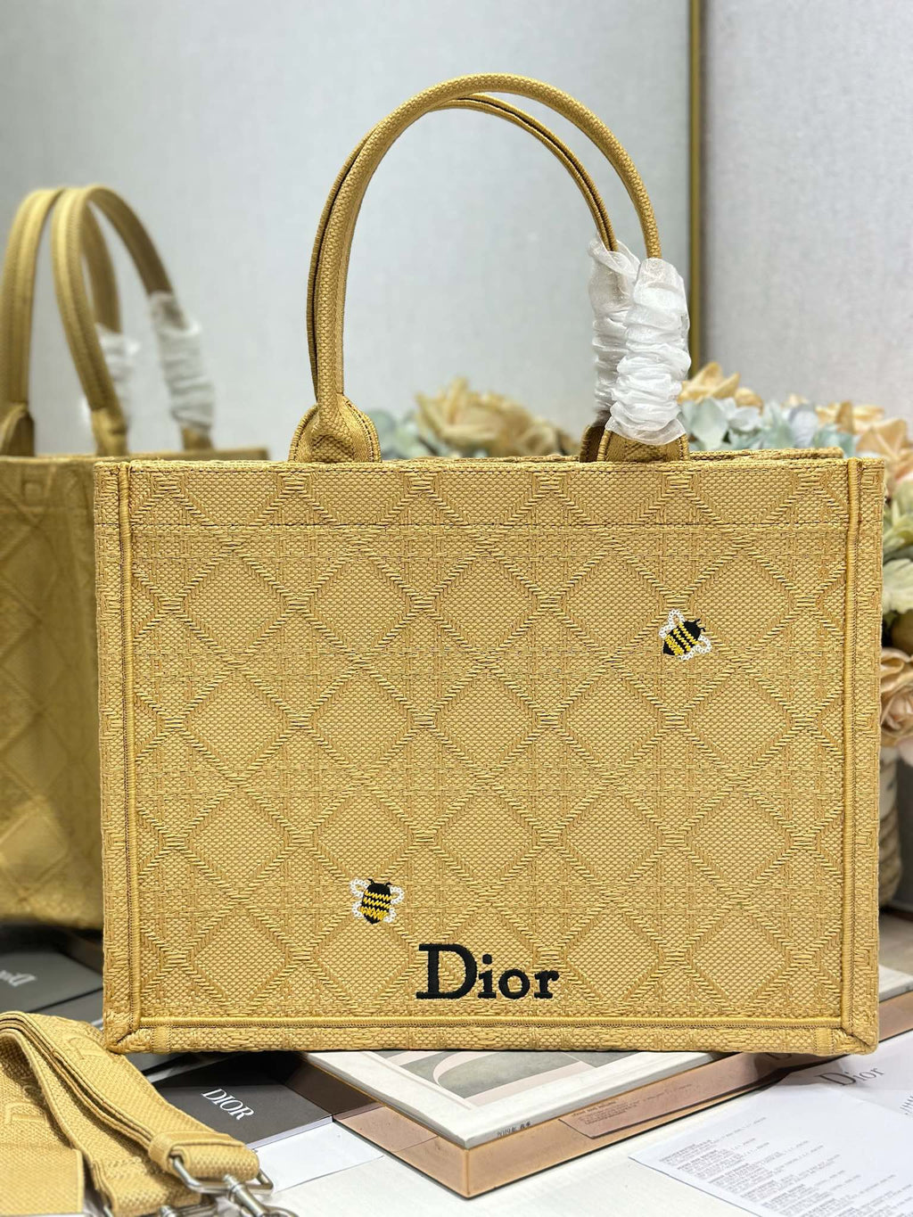 Dior gold handbag with top handles and white tie detail, front Dior logo on panel.