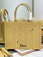 Dior gold handbag with top handles and white tie detail, front Dior logo on panel.
