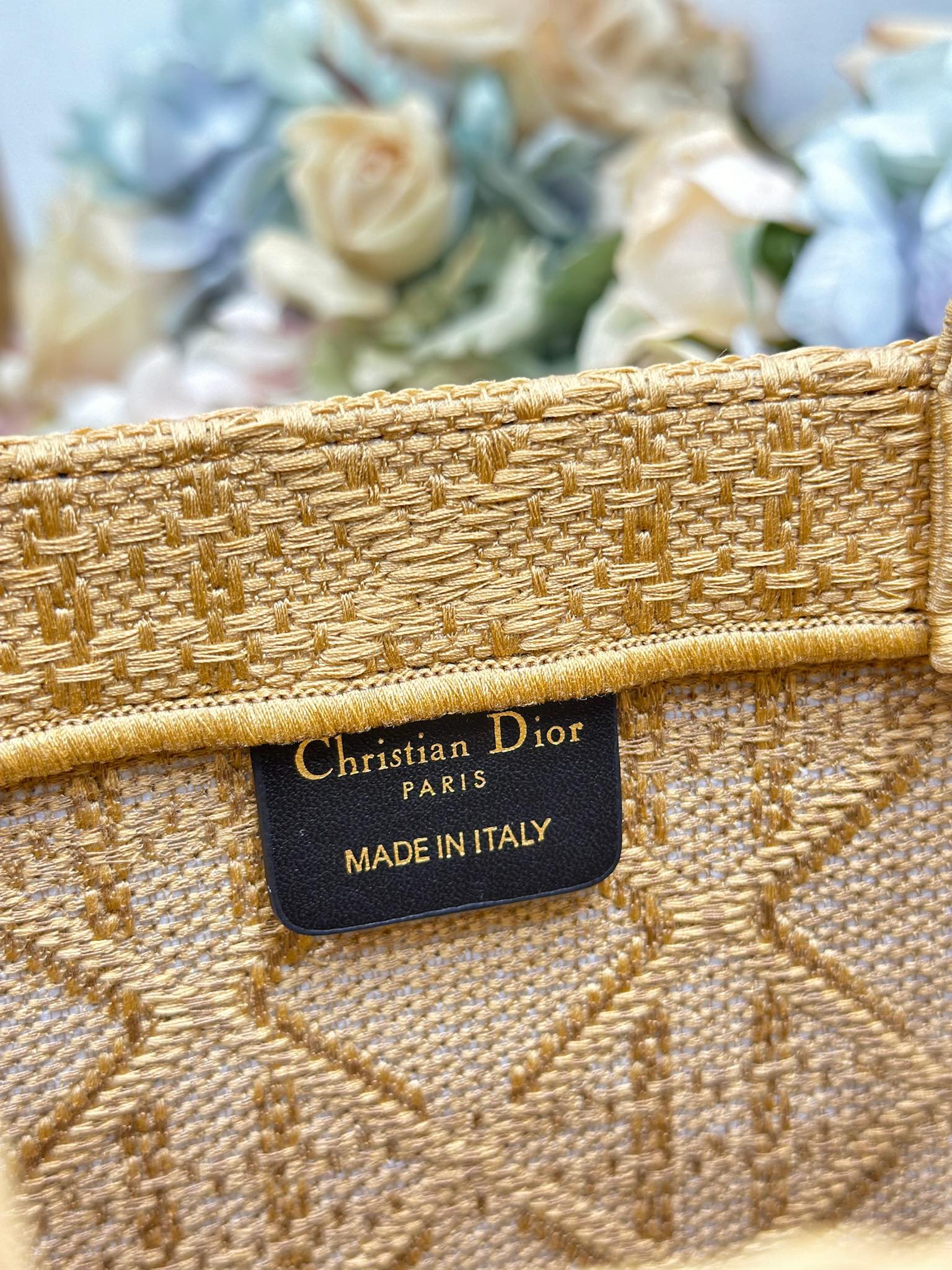 Dior gold handbag close-up of interior leather tag: Christian Dior, Made in Italy.