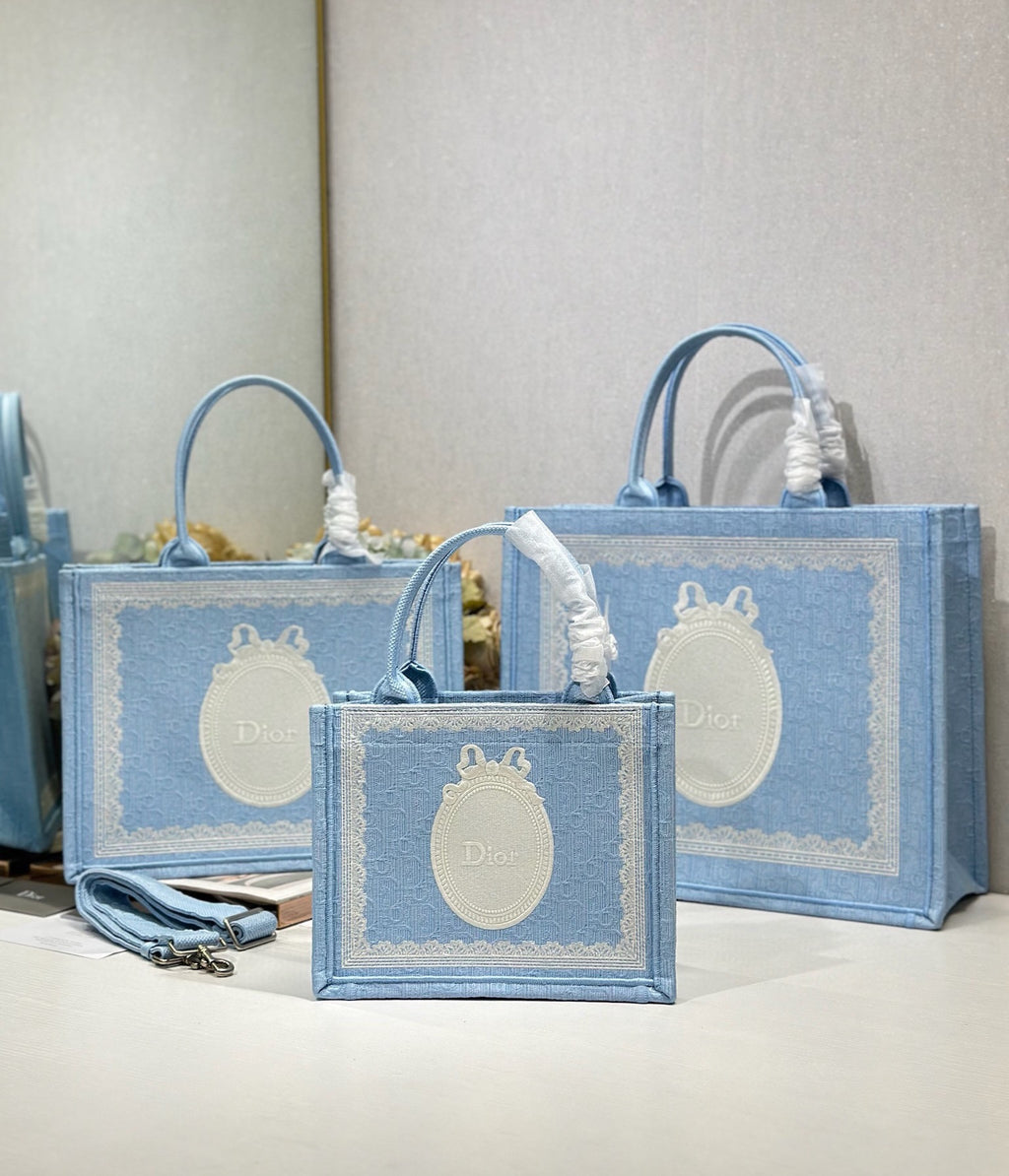 Light blue Dior tote bags with oval white logo and braided handle tassels