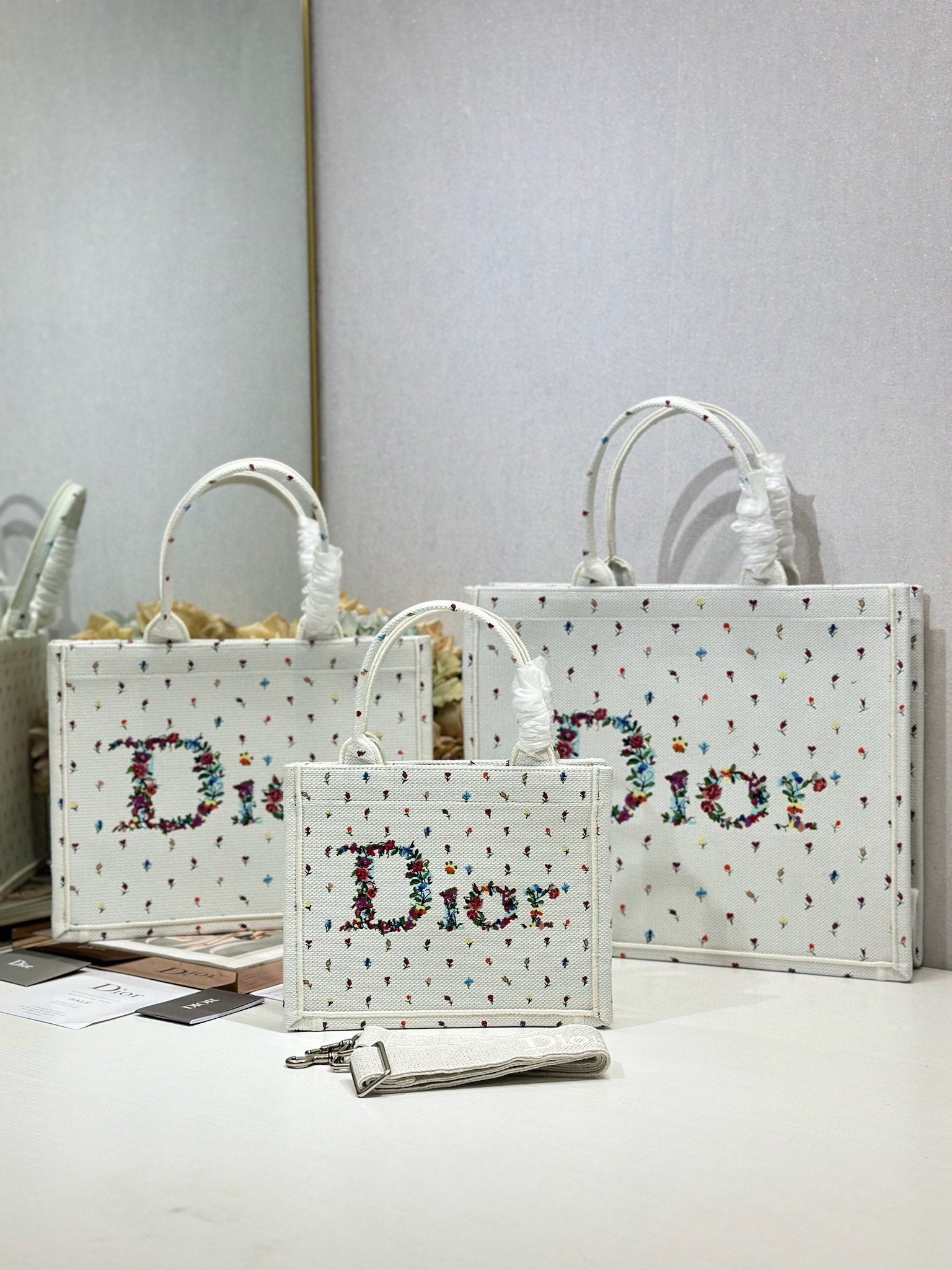 White Dior tote bags with multicolor speckled pattern and large 'Dior' print