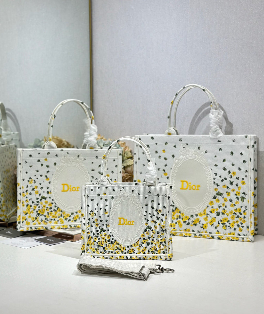 White Dior tote bags with yellow speckled print and oval logo medallions