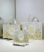 White Dior tote bags with yellow speckled print and oval logo medallions